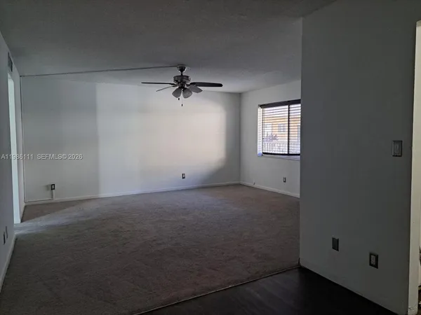 an empty room with a empty space and a ceiling fan