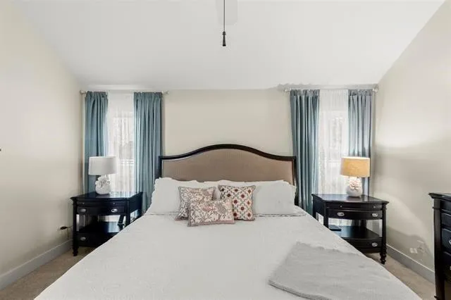 a bedroom with a bed a mirror on dresser and a window