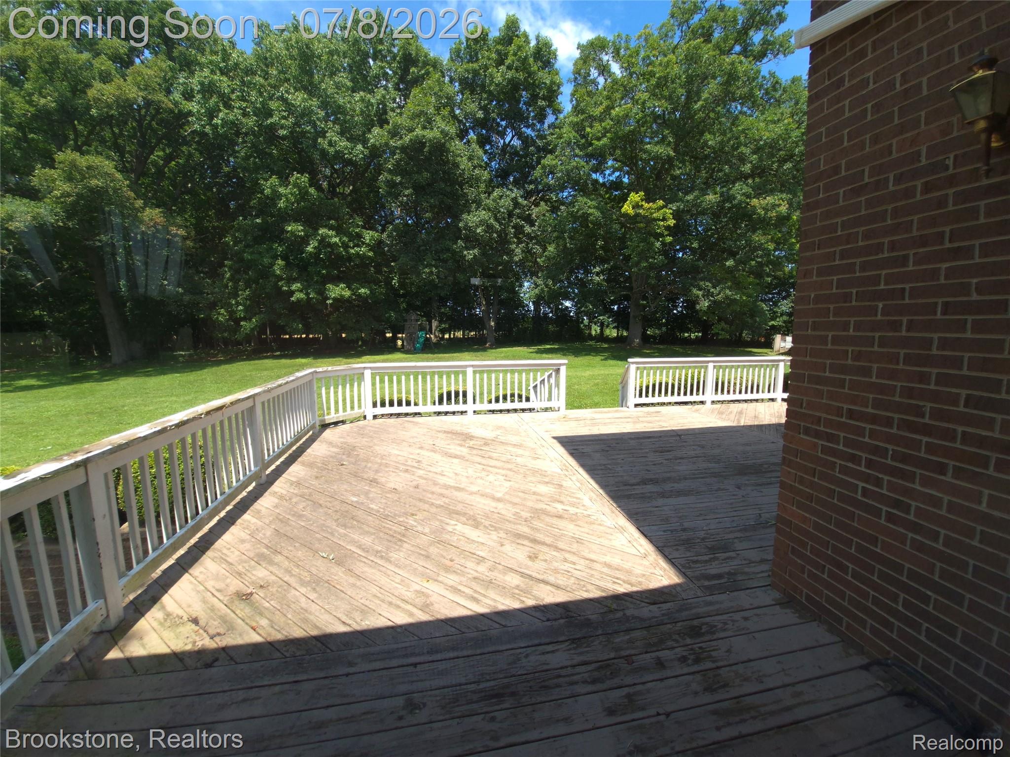4140 South Henderson Road Davison, MI 48423 - Photo 97 of 98 Expansive multi-level wood deck featuring white railings, surrounded by a lush green lawn and mature trees
