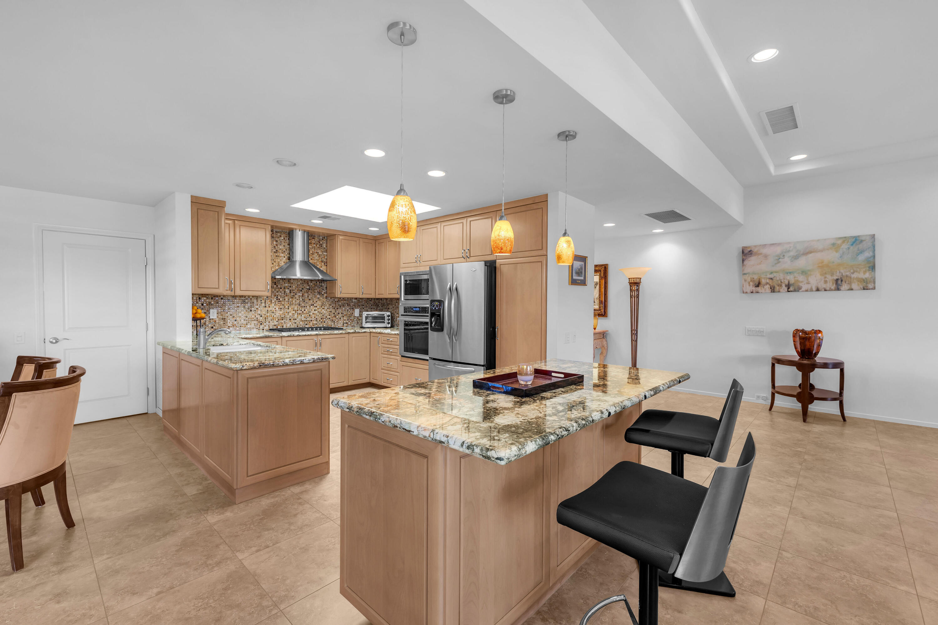 10 Colgate Drive Rancho Mirage, CA 92270 - Photo 11 of 49 a kitchen with kitchen island a stove a table and chairs in it