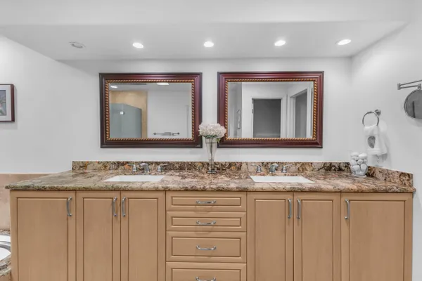 a spacious bathroom with a granite countertop sink and a mirror
