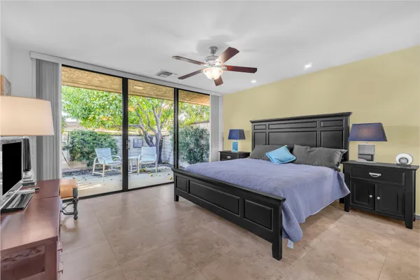 a bedroom with a bed flat screen tv and a large window