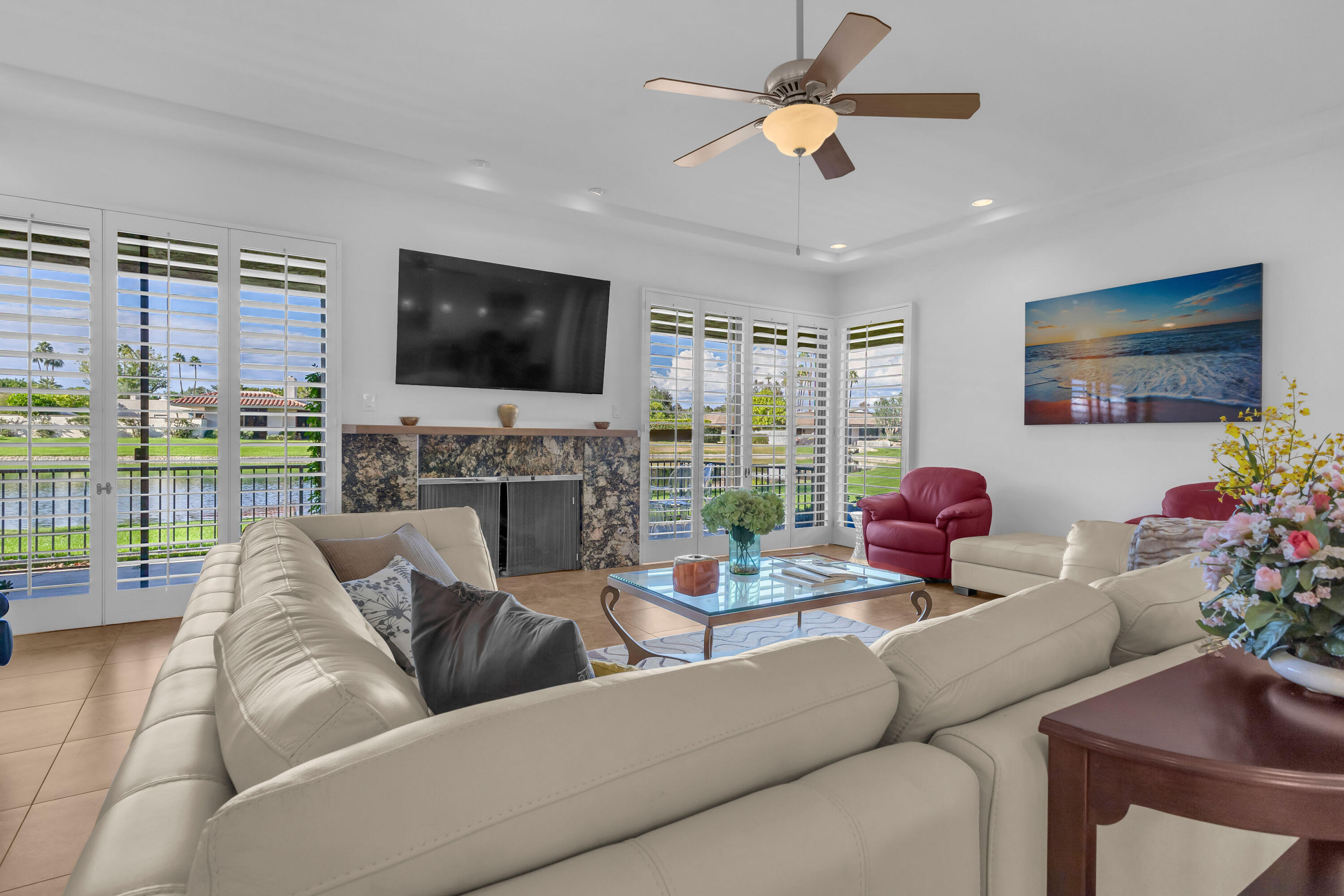 10 Colgate Drive Rancho Mirage, CA 92270 - Photo 5 of 49 a living room with furniture a flat screen tv and a floor to ceiling window