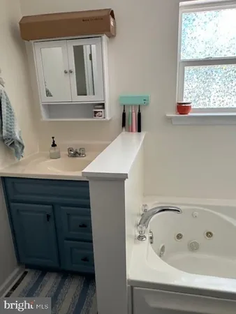 a bathroom with a bathtub sink and mirror