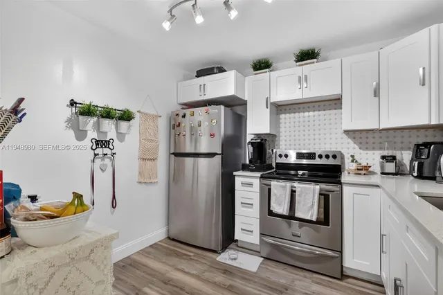 a kitchen with stainless steel appliances granite countertop a refrigerator and a stove