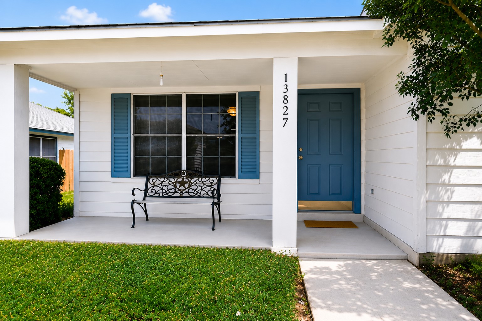 13827 Spring Heath Road Pflugerville, TX 78660 - Photo 2 of 20 A welcoming front porch features a bold blue door, complementing crisp white siding and neatly trimmed greenery. Digitally Enhanced.