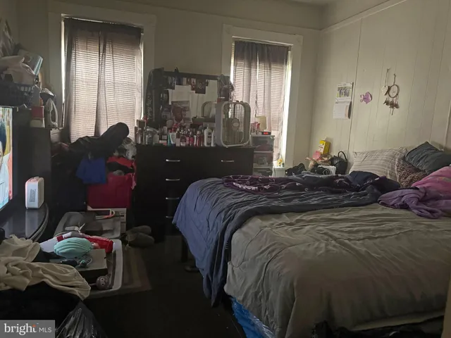 a bed sitting in a bedroom next to a window and a mirror