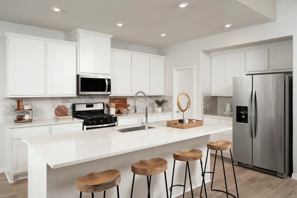 420 Ridgewell Loop Georgetown, TX 78633 - Photo 11 of 25 a kitchen with a sink a table and chairs