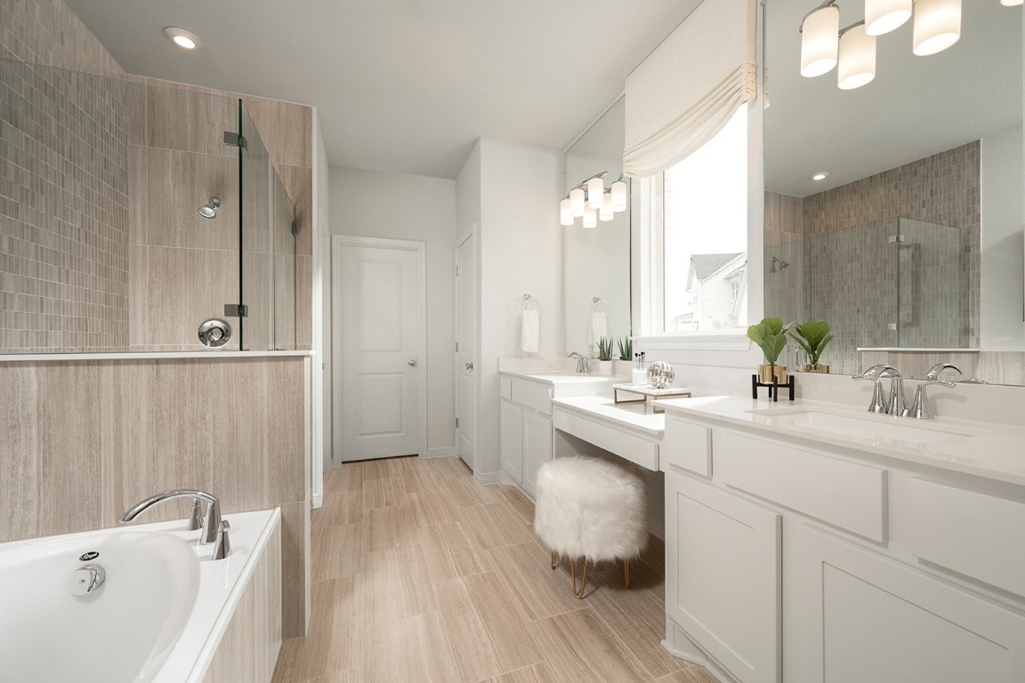 420 Ridgewell Loop Georgetown, TX 78633 - Photo 15 of 25 a bathroom with a double vanity sink a mirror and a bathtub
