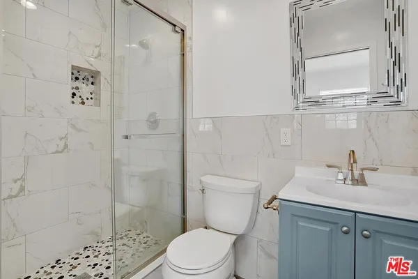 a bathroom with a sink a toilet and shower