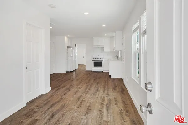 a view of a kitchen with wooden floor and a refrigerator