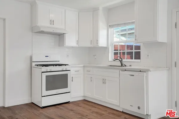 a kitchen with white cabinets and a sink