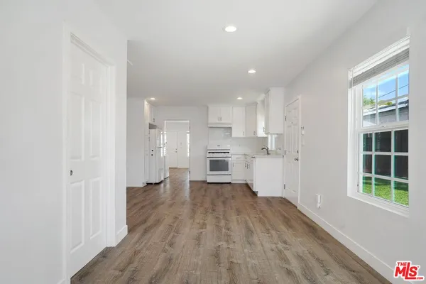 a view of a kitchen with wooden floor and a window
