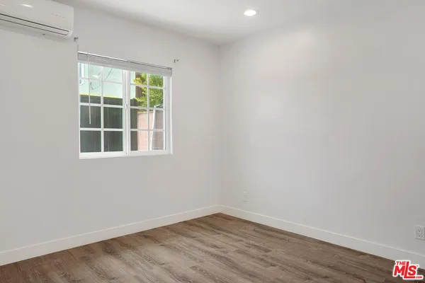 a view of empty room with window and wooden floor