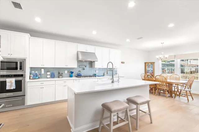 a kitchen with stainless steel appliances kitchen island granite countertop a sink and cabinets