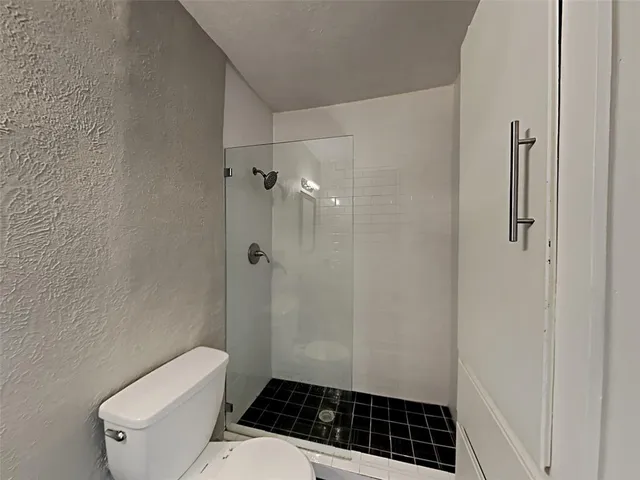 a bathroom with a toilet a sink and shower