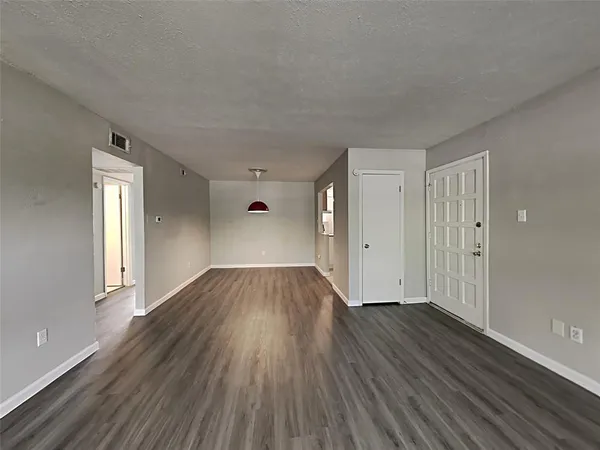 a view of empty room with wooden floor and window