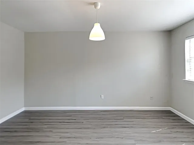 a view of a room with wooden floor and window