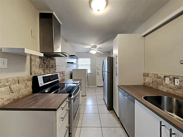 a kitchen with stainless steel appliances granite countertop a sink a stove and a refrigerator