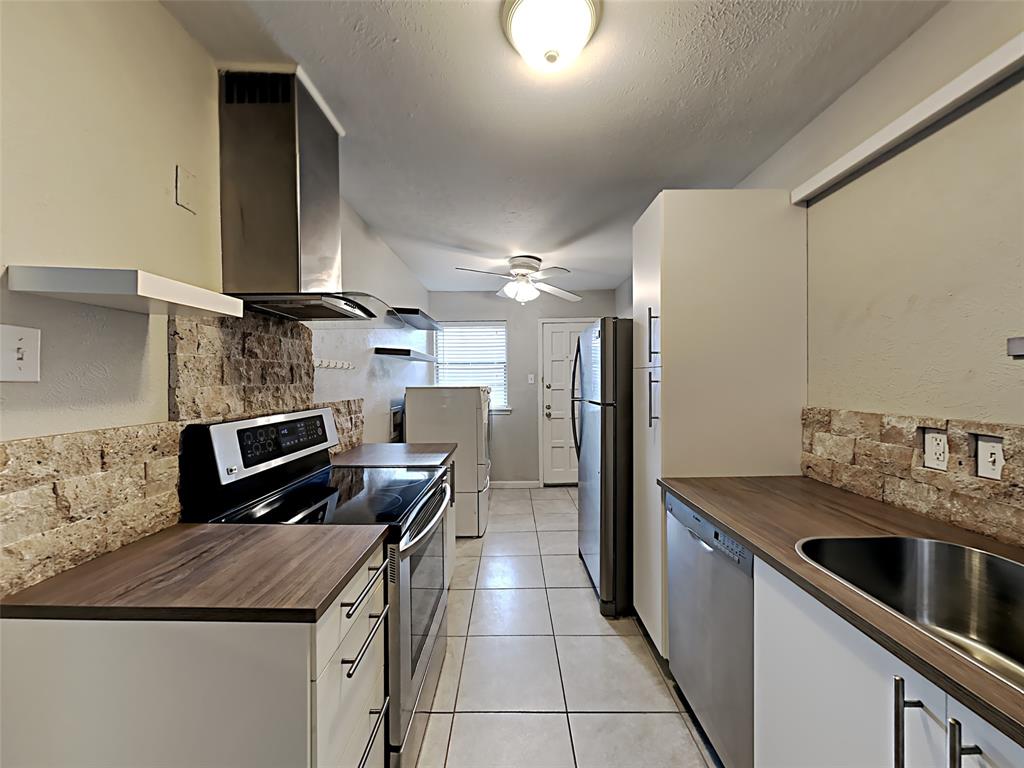 5105 Skillman Street, Unit 120E Dallas, TX 75206 - Photo 6 of 15 a kitchen with stainless steel appliances granite countertop a sink a stove and a refrigerator