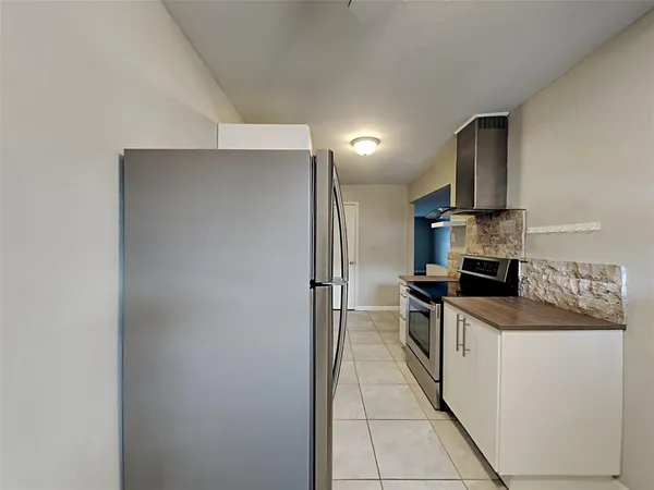 a kitchen with stainless steel appliances granite countertop a sink and a refrigerator