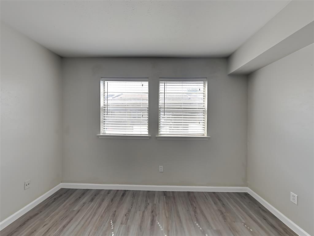 5105 Skillman Street, Unit 120E Dallas, TX 75206 - Photo 9 of 15 an empty room with wooden floor and windows