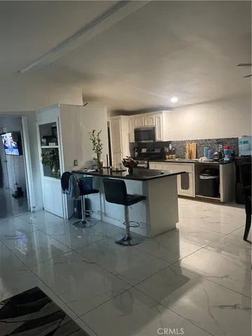 a kitchen with a counter top space a sink and stainless steel appliances