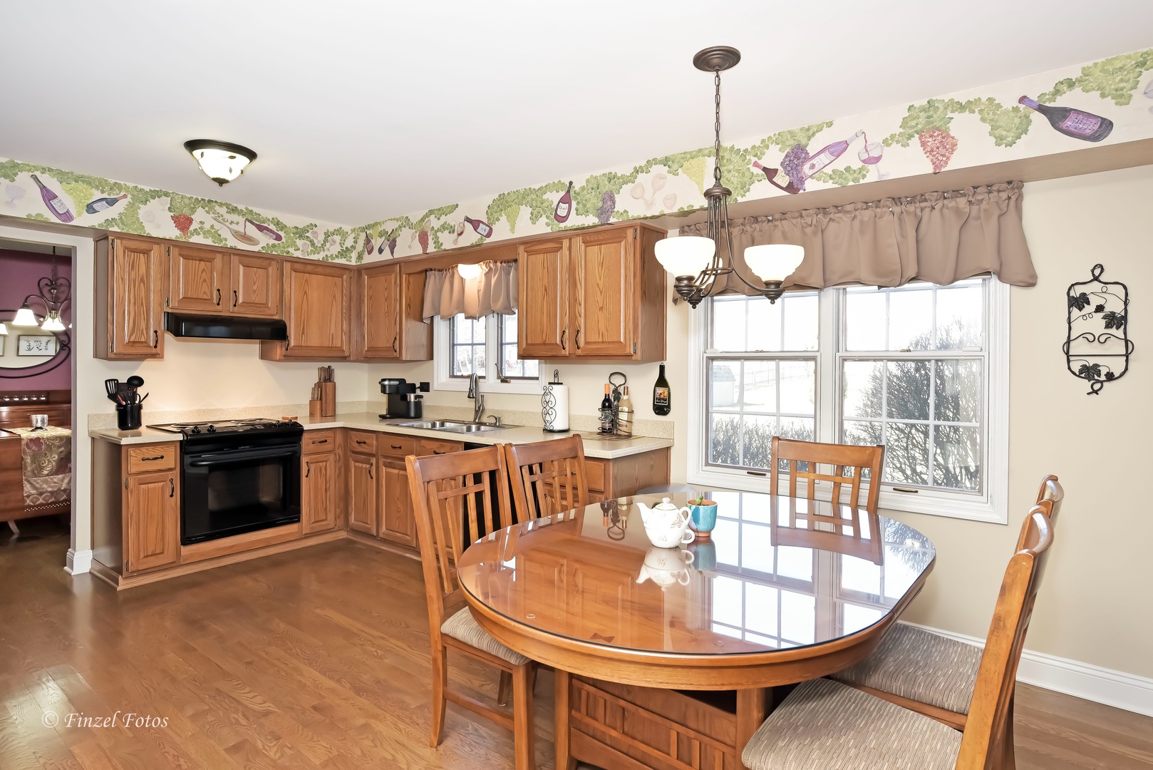 34108 Homestead Road Gurnee, IL 60031 - Photo 2 of 16 a open kitchen with stainless steel appliances granite countertop a stove a sink a microwave a dining table and chairs with wooden floor