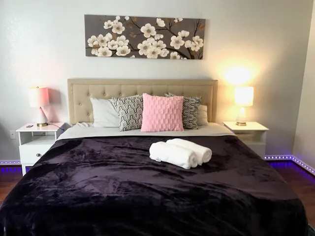 a bedroom with a bed and a painting on the wall