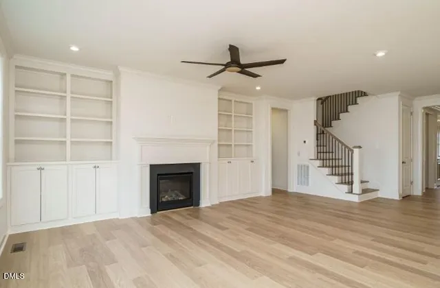 a view of empty room with wooden floor and fireplace