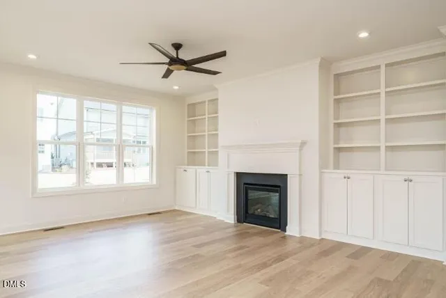 an empty room with windows and fireplace