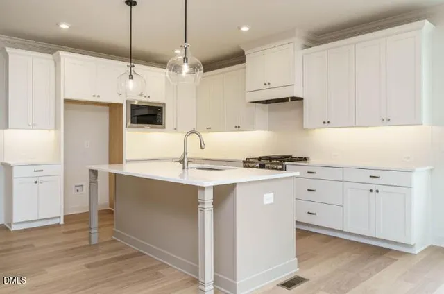 a kitchen with stainless steel appliances granite countertop a sink a stove and a refrigerator