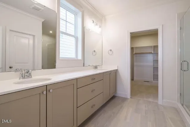 a bathroom with a double vanity sink and mirror with shower