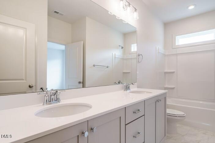 749 West Holly Springs Road Holly Springs, NC 27540 - Photo 34 of 42 a bathroom with a sink a toilet and a large mirror