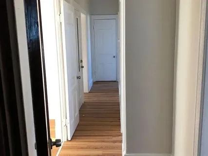 a view of a hallway with wooden floor
