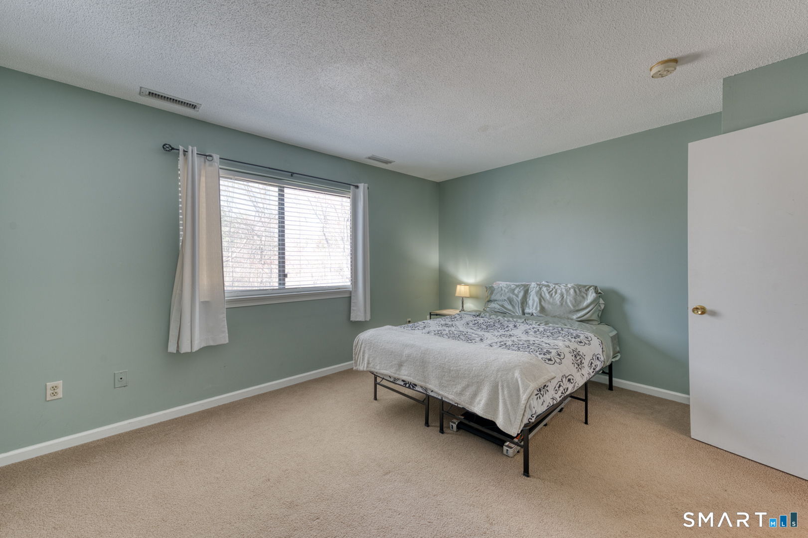 78 Silo Way, Unit 78 Bloomfield, CT 06002 - Photo 19 of 27 a bedroom with a bed lamp and window
