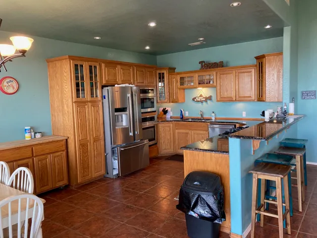 a kitchen with stainless steel appliances granite countertop a refrigerator stove and sink