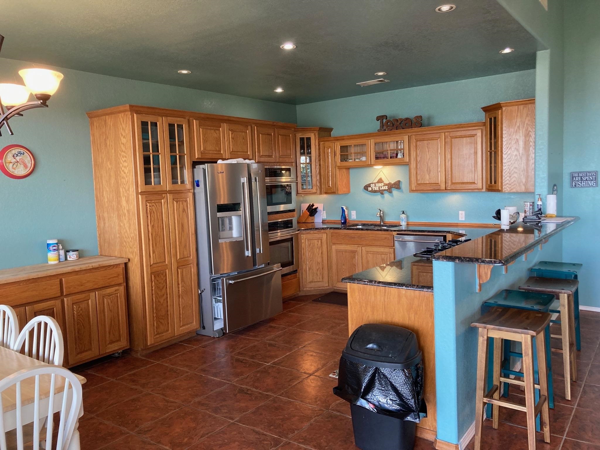 215 Mountain Top Sunrise Beach, TX 78643 - Photo 4 of 29 a kitchen with stainless steel appliances granite countertop a refrigerator and a sink