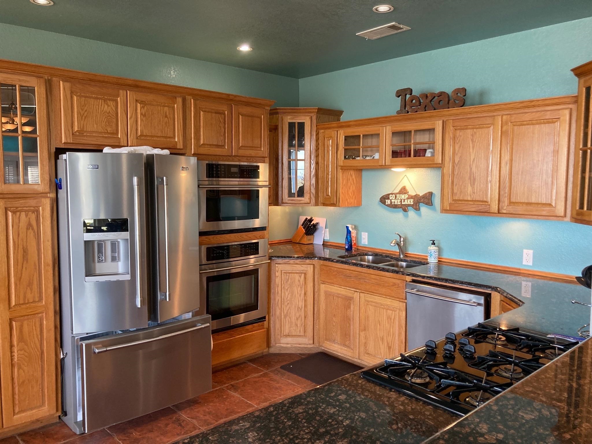 215 Mountain Top Sunrise Beach, TX 78643 - Photo 5 of 29 a kitchen with stainless steel appliances granite countertop a refrigerator stove and sink
