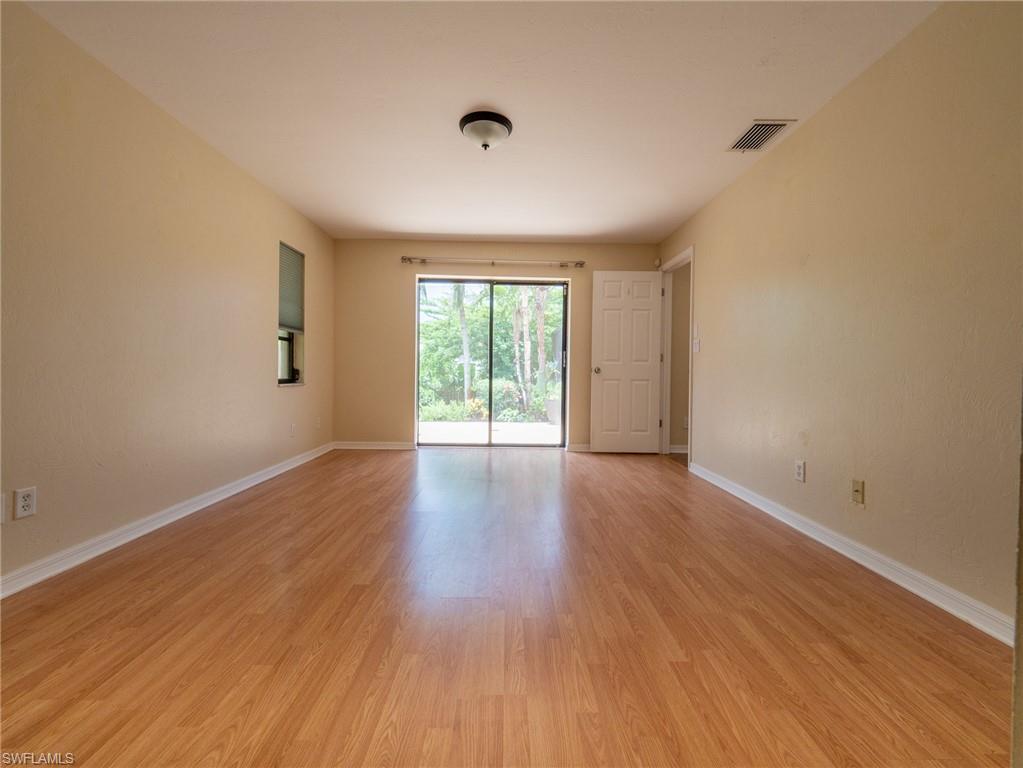 18414 Tulip Road Fort Myers, FL 33967 - Photo 19 of 37 Expansive room featuring wood-finish flooring, neutral-toned walls, and a recessed window