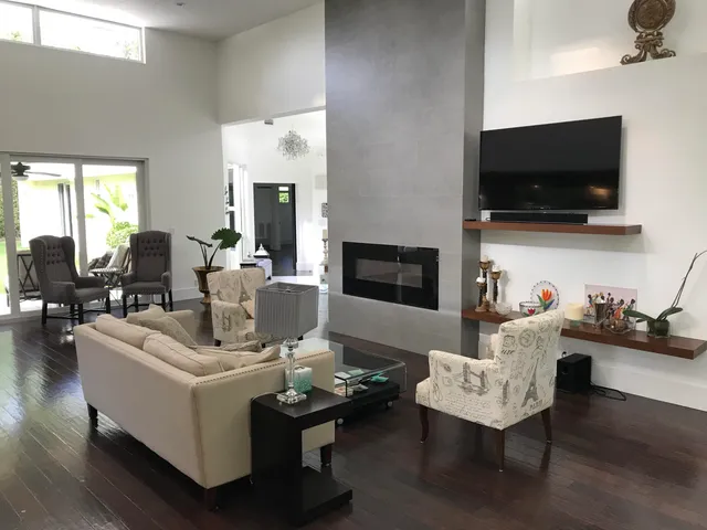 a living room with furniture a flat screen tv and kitchen view