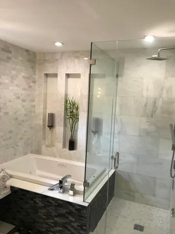 a bathroom with a tub shower and sink
