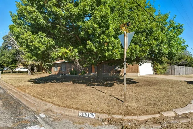 a tree in front of a white house