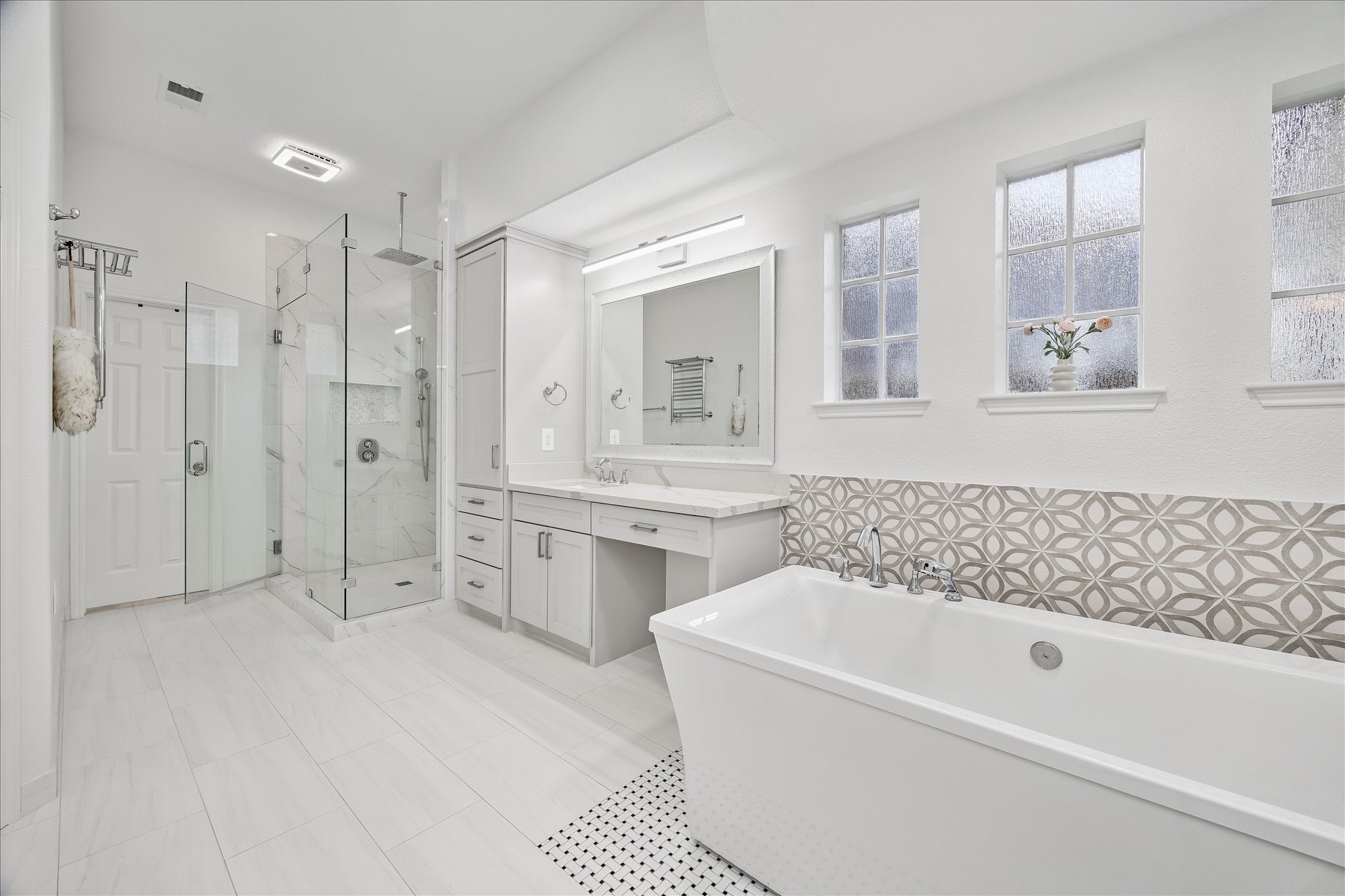 15 West Beckonvale Circle The Woodlands, TX 77382 - Photo 20 of 44 The luxurious, renovated primary bathroom is a serene space to begin each day. A dedicated seating area makes the perfect space to sit and freshen up.