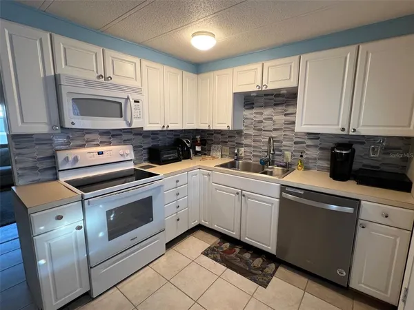 a kitchen with cabinets appliances and a window