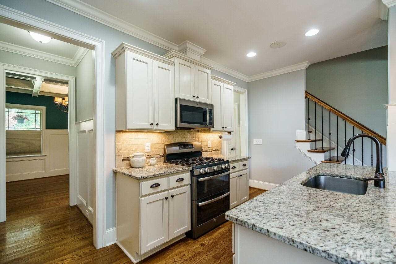 6219 Blanche Drive Raleigh, NC 27607 - Photo 14 of 30 a kitchen with granite countertop a stove top oven and cabinets
