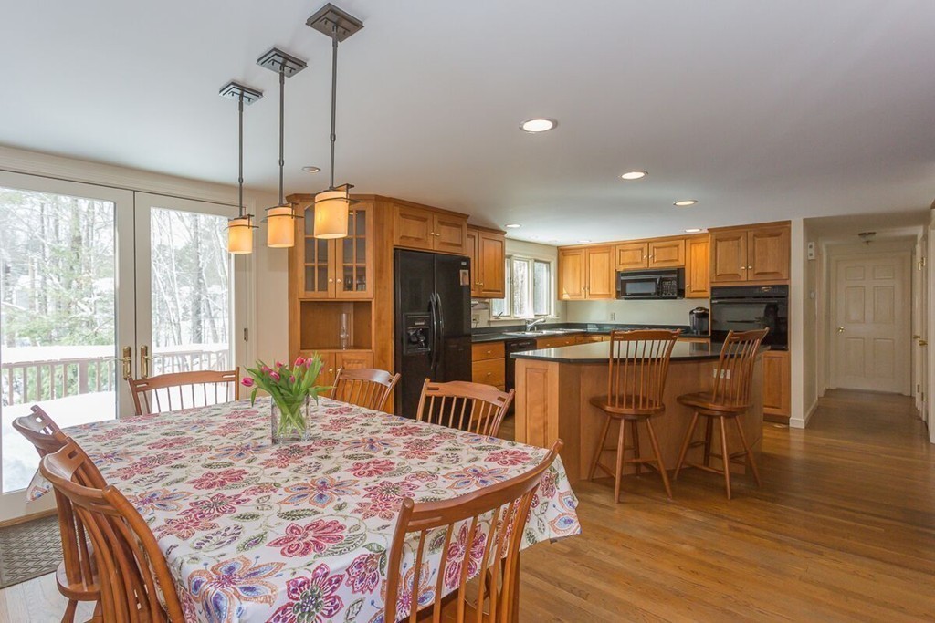 18 Sunrise Road Boxford, MA 01921 - Photo 8 of 22 a kitchen with stainless steel appliances granite countertop a table chairs and a wooden floor