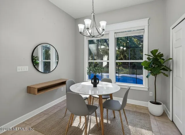 a dining room with furniture potted plants and a chandelier