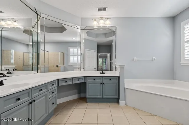 a bathroom with a granite countertop sink a large mirror and a bathtub