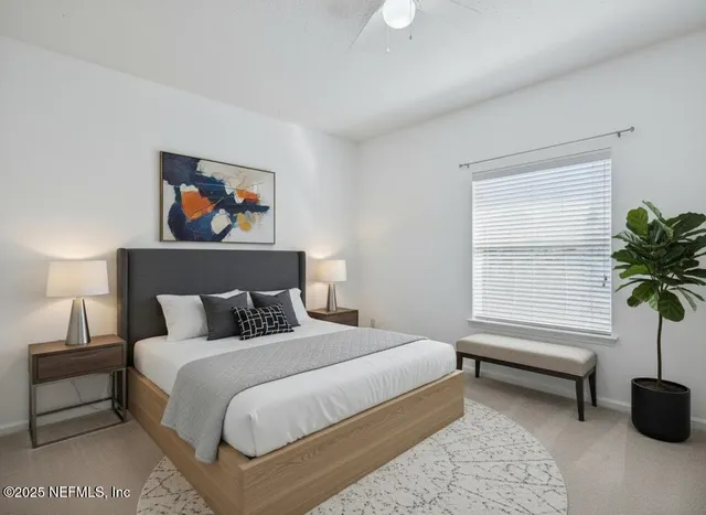 a bedroom with bed and a potted plant